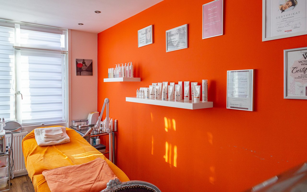 Behandelbank voor de oranje muur met ingelijste diploma's en planken met producten