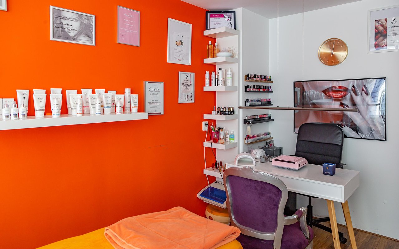 Manicuretafel voor de wand met gellak en producten op de oranje muur