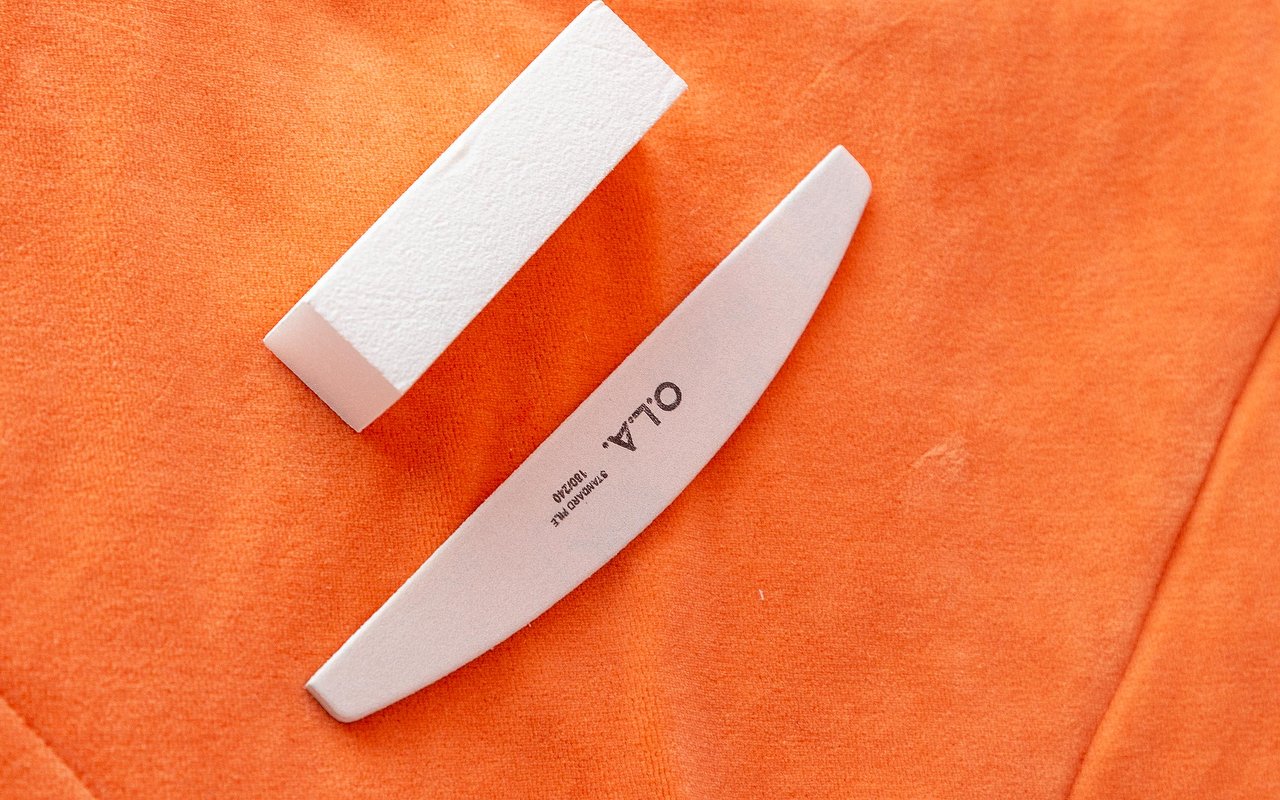 Nagelvijl en buffer op een oranje handdoek